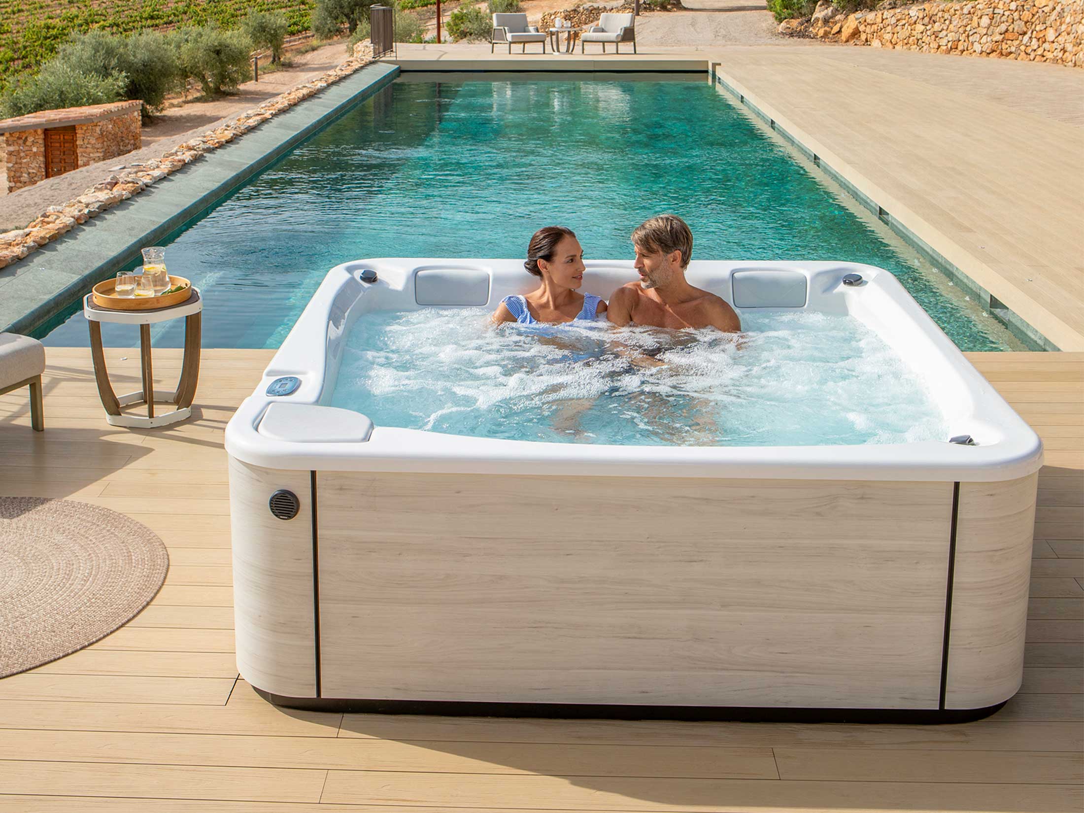 Lyxigt utomhusspa med par och pool bakom